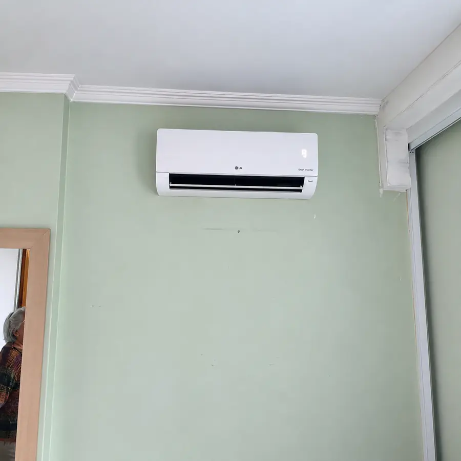 Ar-condicionado split instalado em uma parede verde
